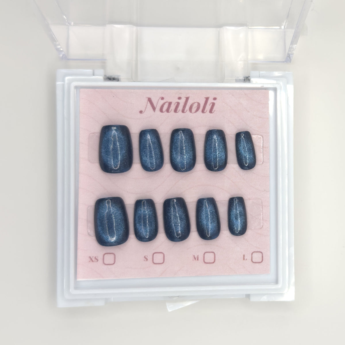 Midnight cat eye nail set on its backing card inside the clear Nailoli case