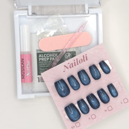 Open Nailoli case with the midnight set, glue, adhesive tabs, prep pad, nail file, and cuticle stick