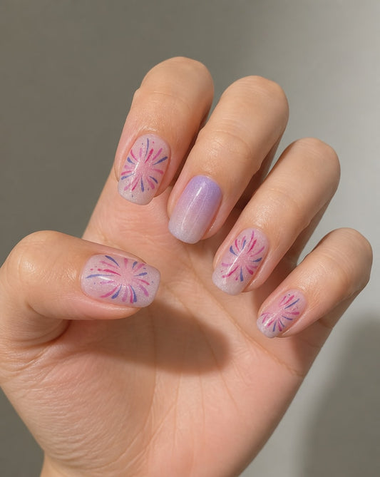 Hand wearing sheer lavender ombre square press-ons with pink and purple starburst line art