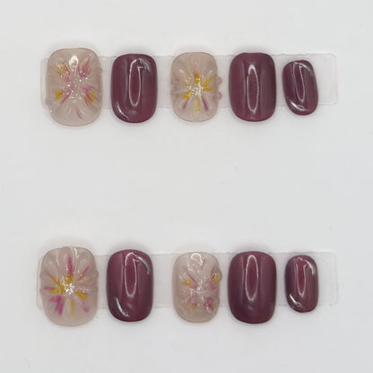 10 press-ons in two rows: glossy mauve nails and sheer nails with pink and yellow watercolor florals