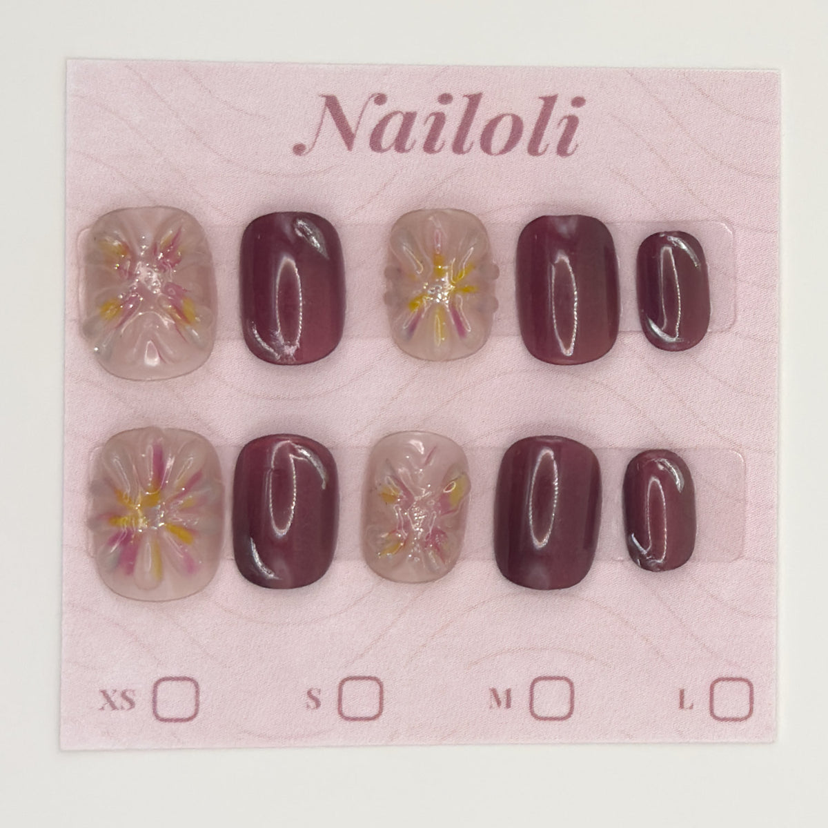 Mauve blossom nails on the pink Nailoli backing card with XS, S, M, and L size boxes
