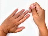 Pushing back cuticles with a cuticle pusher before applying press-on nails