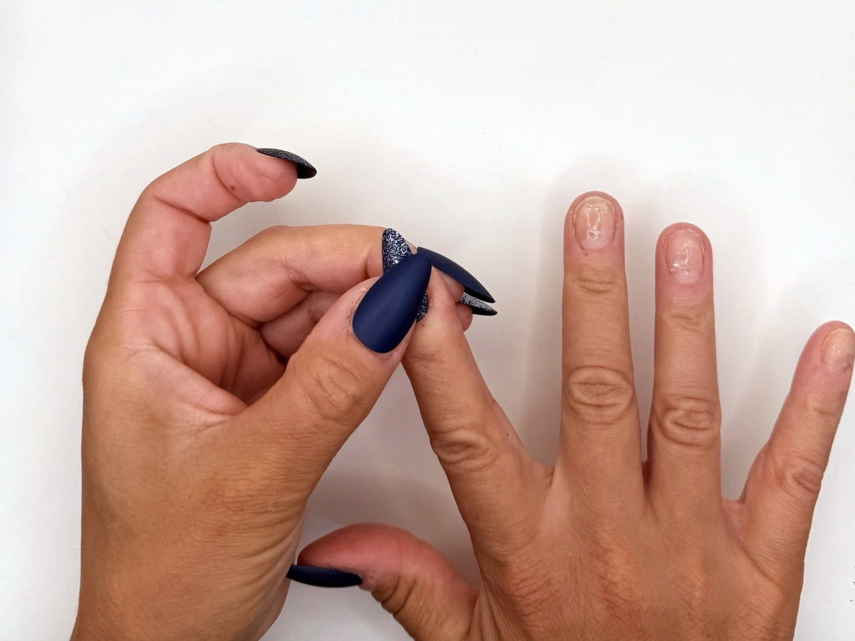 Clear adhesive tabs on bare nails, ready for navy press-on nails