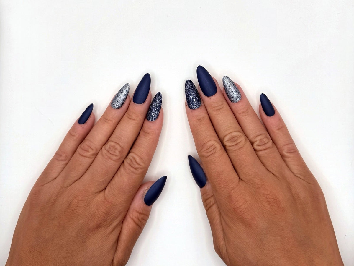 Both hands side by side with a full set of navy matte and glitter press-on nails