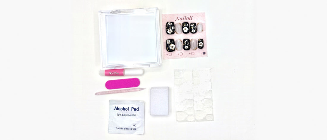 Nailoli Signature set with nail glue, a sheet of adhesive tabs, nail file, buffing block, cuticle pusher, alcohol pad, and case